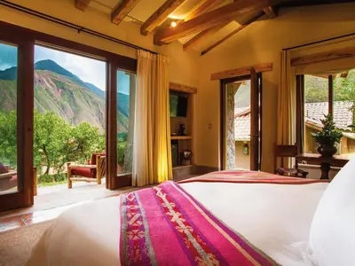a bedroom with a bed with a view of a mountain at Inkaterra Hacienda Urubamba in Urubamba