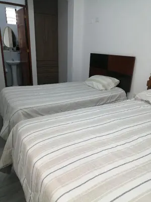 two beds sitting next to each other in a bedroom at Alojamiento Miller in Ayacucho