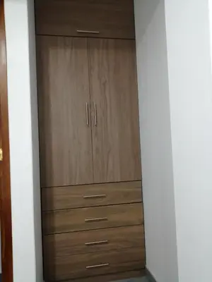 a closet with wooden cabinets in a room at Alojamiento Miller in Ayacucho
