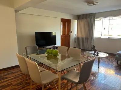 a dining room with a glass table and chairs at Apartment - US Embassy in Lima