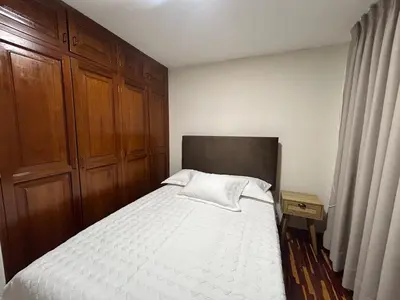 a bedroom with a large bed with a wooden headboard at Apartment - US Embassy in Lima