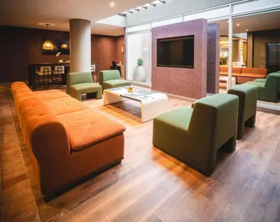 a lobby with a couch and chairs and a tv at Hampton By Hilton Cusco in Cusco
