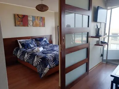 a bedroom with a bed and a sliding door at Panoramic Elegante departamento in Lima