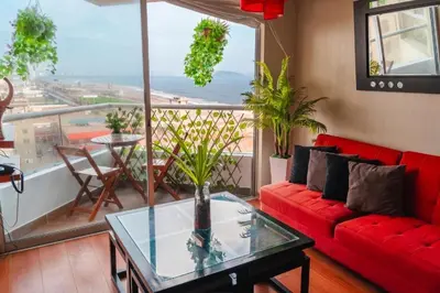 a living room with a red couch and a glass table at Panoramic Elegante departamento in Lima