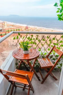 a table and two chairs on a balcony with the beach at Panoramic Elegante departamento in Lima