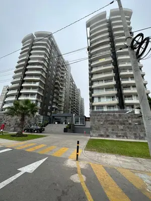 two tall apartment buildings in a parking lot at Panoramic Elegante departamento in Lima