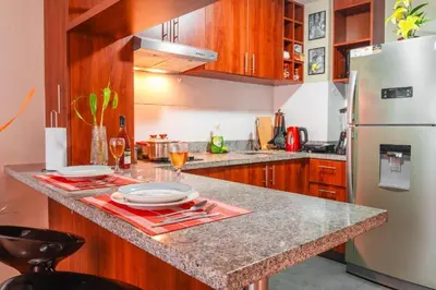 a kitchen with a granite counter top and a refrigerator at Panoramic Elegante departamento in Lima