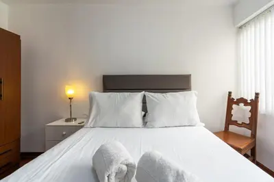 a bedroom with a white bed with towels on it at Basílica 3BR by Geko in Lima