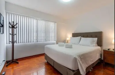 a bedroom with a large bed and a large window at Basílica 3BR by Geko in Lima