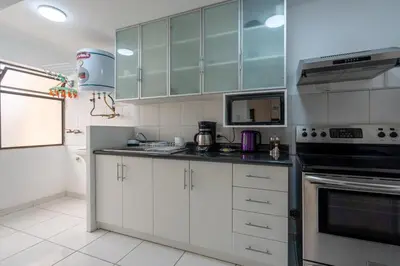 a kitchen with white cabinets and a stove top oven at Basílica 3BR by Geko in Lima
