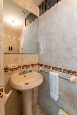 a bathroom with a white sink and a shower at Basílica 3BR by Geko in Lima