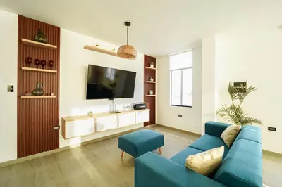 a living room with a blue couch and a tv at Casa de playa en Chincha Baja in Chincha Baja