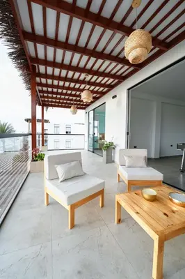 a patio with two couches and a wooden table at Casa de playa en Chincha Baja in Chincha Baja
