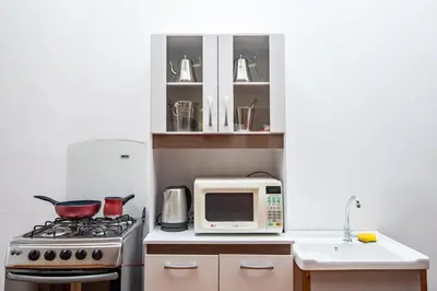 a kitchen with a stove and a microwave at Alojamiento en Centro Histórico Cusco in Cusco