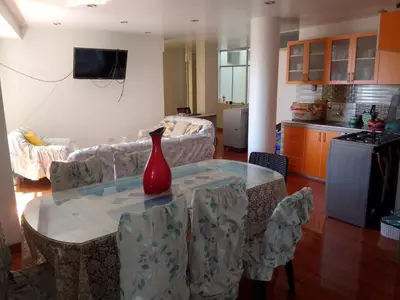 a living room with a table with a vase on it at Macchi in Ayacucho