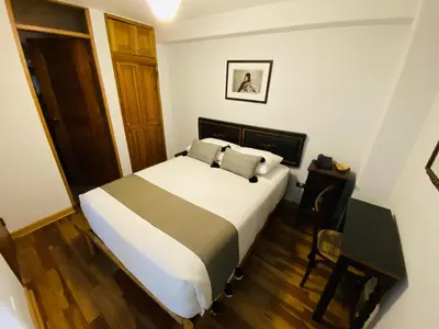 a bedroom with a bed and a table and a chair at Artinka Boutique Hotel in Cusco
