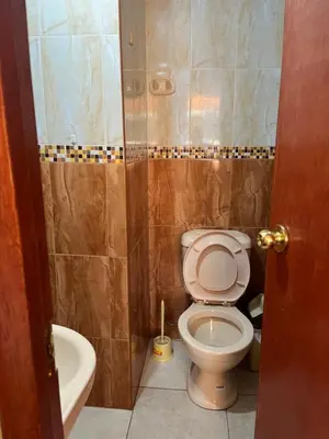 a bathroom with a toilet and a sink and a tub at Habitación 2 camas y baño privado in Ayacucho