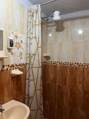 a bathroom with a shower and a toilet and a sink at Habitación 2 camas y baño privado in Ayacucho