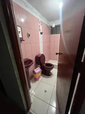 a bathroom with two toilets in a pink bathroom at Habitación 2 camas in Ayacucho