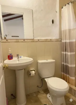 a bathroom with a toilet and a sink and a mirror at Naty's Guest House in Cusco