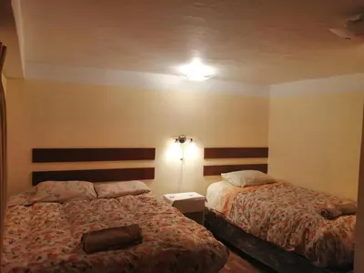 a hotel room with two beds and a lamp at Naty's Guest House in Cusco