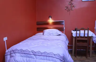 a bedroom with a bed in a red wall at Naty's Guest House in Cusco