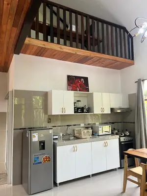a kitchen with white cabinets and a stove at Albano Casa en bosque de conservación privado in Oxapampa