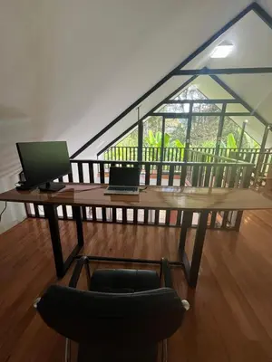 a table with a laptop and a chair in a room at Albano Casa en bosque de conservación privado in Oxapampa