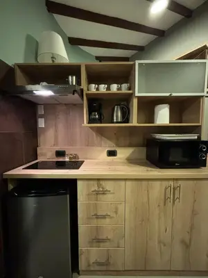 a kitchen with wooden cabinets and a black refrigerator at Serendipia Studio Loft in San Isidro 205 in Lima