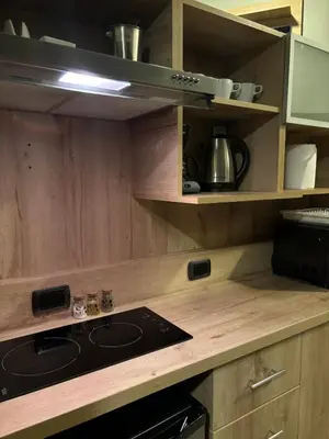 a kitchen with wooden cabinets and a stove top oven at Serendipia Studio Loft in San Isidro 205 in Lima