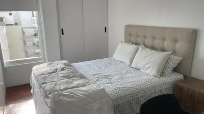a bed with white sheets and pillows in a bedroom at Brand new modern apartment in Lima