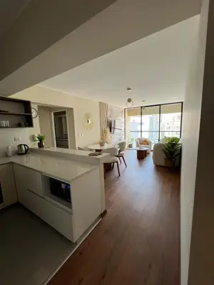 a large kitchen and living room with a table and a couch at Beautiful brand new apartment in an excellent area in Lima