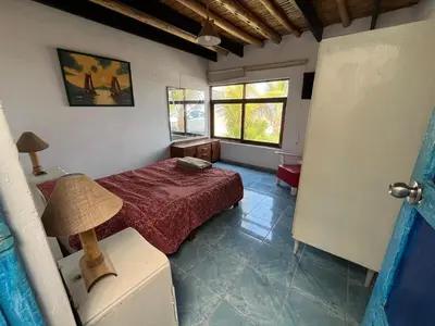 a bedroom with a bed and a lamp in it at Playa El Silencio House Facing the Sea in Bombiso