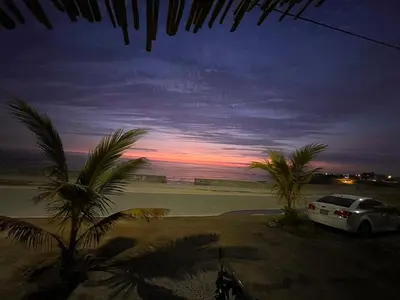 a car parked on a beach with palm trees at Playa El Silencio House Facing the Sea in Bombiso
