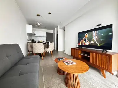 a living room with a couch and a flat screen tv at Apartamento en Miraflores in Lima