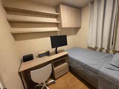 a small bedroom with a bed and a desk with a television at Departamento 3 Dormitorios en Ñaña - Con Cochera in Chosica