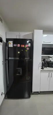 a black refrigerator in a kitchen next to a counter at Departamento 3 Dormitorios en Ñaña - Con Cochera in Chosica