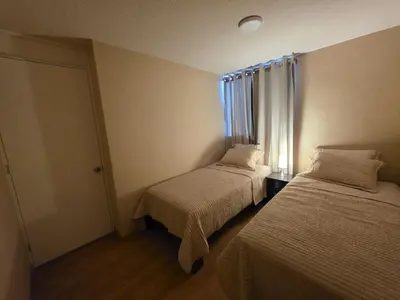 a small room with two beds and a window at Departamento 3 Dormitorios en Ñaña - Con Cochera in Chosica