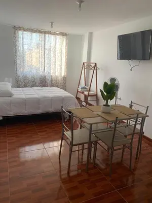 a living room with a bed and a table and chairs at Minidepartamentos Amoblado I en Estreno in Ica