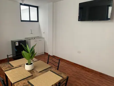 a dining room with a table with chairs and a television at Minidepartamentos Amoblado III en Estreno in Ica