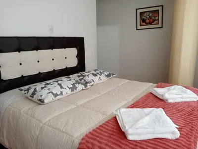 a bed with two towels sitting on top of it at Apartamento familiar 9 personas tranporte incluido in Cusco
