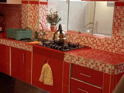 a red kitchen with a stove and a pot on it at Apartamento familiar 9 personas tranporte incluido in Cusco
