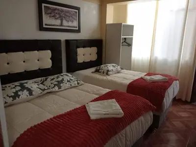 a hotel room with two beds with towels on them at Apartamento familiar 9 personas tranporte incluido in Cusco