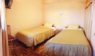 a room with two beds in a room at Hostal Lucerito in Cusco