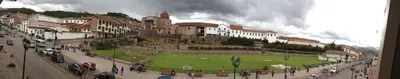 a group of people walking down a street in a city at Hostal Lucerito in Cusco