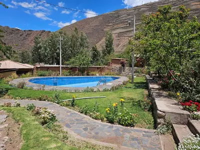 a garden with a swimming pool in front of a mountain at Condominio Villa Andina in Urubamba