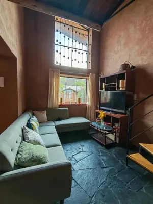 a living room with a couch and a television at Condominio Villa Andina in Urubamba