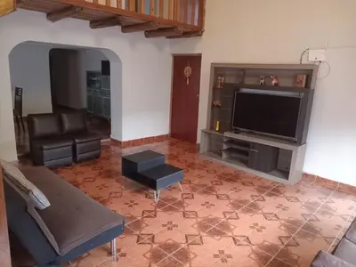 a living room with a couch and a television at The yellow house in the valley in Urubamba