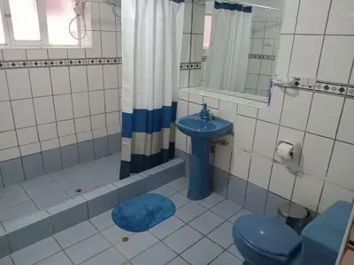 a bathroom with a blue toilet and a sink at The yellow house in the valley in Urubamba