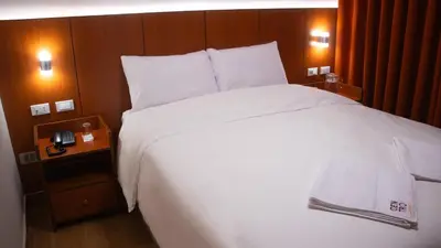 a large white bed in a hotel room at Hotel Centro Huancayo in Huancayo